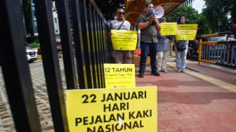 Aktivis dari Koalisi Pejalan Kaki menggelar aksi di Halte Tugu Tani, Jakarta, Senin (22/1/2024). [Suara.com/Alfian Winanto]