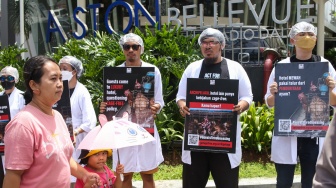 Sejumlah aktivis Act For Farmed Animals (AFFA) memakai jubah mandi sambil melakukan aksi di depan Hotel Aston Bellevue Radio Dalam, Senin (22/1/2024). [Suara.com/Alfian Winanto]