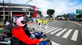 Aktivis dari Koalisi Pejalan Kaki menggelar aksi di Halte Tugu Tani, Jakarta, Senin (22/1/2024). [Suara.com/Alfian Winanto]