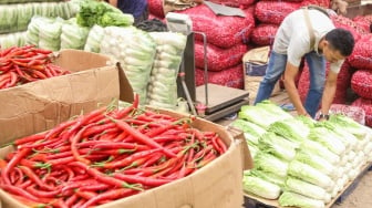 Pedagang menata barang dagangannya di Pasar Induk Kramat Jati, Jakarta, Senin (29/1/2024). [Suara.com/Alfian Winanto]