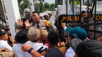 Massa Gabungan dari Kepala Desa se-Indonesia menerobos masuk kedalam usai menjebol pagar saat melakukan aksi di depan Gedung DPR RI, Jakarta, Rabu (31/1/2024). [Suara.com/Alfian Winanto]