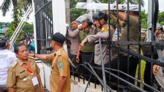 Massa Gabungan dari Kepala Desa se-Indonesia menerobos masuk kedalam usai menjebol pagar saat melakukan aksi di depan Gedung DPR RI, Jakarta, Rabu (31/1/2024). [Suara.com/Alfian Winanto]