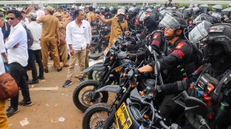 Massa Gabungan dari Kepala Desa se-Indonesia menghadang anggota Brimob saat melakukan aksi di depan Gedung DPR RI, Jakarta, Rabu (31/1/2024). [Suara.com/Alfian Winanto]