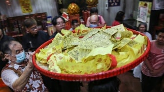 Seorang warga etnis Tionghoa membawa kertas doa sebelum dibakar bersama dalam prosesi ritual sembahyang Sang Sin di Klenteng Siu Hok Bio, Semarang, Jawa Tengah, Sabtu (3/2/2024). [ANTARA FOTO/Makna Zaezar/rwa]