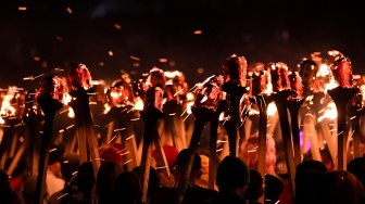 Anggota parade Up Helly Aa 'Jarl Squad' melintas sambil membawa obor saat Festival Up Helly Aa di Lerwick, Kepulauan Shetland, Skotlandia, Selasa (30/1/2024). [ANDY BUCHANAN / AFP] 