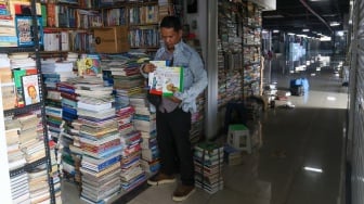 Pedagang merapikan buku jualannya di Sentra Buku Pasar Kenari, Jakarta, Senin (5/2/2024). [Suara.com/Alfian Winanto]