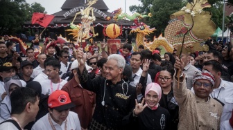 Capres-cawapres nomor urut 3 Ganjar Pranowo (tengah) dan Mahfud MD (kanan) mengangkat wayang saat mengikuti kirab kampanye akbar di Solo, Jawa Tengah, Sabtu (10/2/2024). [ANTARA FOTO/Mohammad Ayudha].