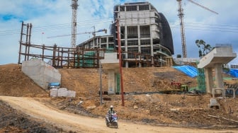 Pekerja melintas di depan pembangunan istana presiden Ibu Kota Nusantara (IKN), Kabupaten Penajam Paser Utara, Kalimantan Timur, Senin (12/2/2024). [ANTARA FOTO/ Rivan Awal Lingga].