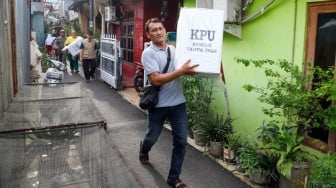 Sejumlah petugas membawa logistik Pemilu 2024 menuju tempat pemungutan suara di RW 02 Paseban, Jakarta, Selasa (13/2/2024). [Suara.com/Alfian Winanto]