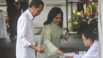 Presiden Joko Widodo (kiri) bersama Ibu Negara Iriana (kanan) mencelupkan jari ke dalam tinta usai menggunakan hak suaranya pada Pemilu 2024 di tempat pemungutan suara (TPS) 10 Kelurahan Gambir, kompleks Kantor Lembaga Administrasi Negara (LAN), Jakarta, Rabu (14/2/2024). [ANTARA FOTO/Muhammad Adimaja].