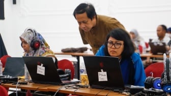 Petugas memantau hasil rekapitulasi sementara pemungutan suara Pemilihan Umum (Pemilu) 2024 di Gedung Komisi Pemilihan Umum (KPU) Republik Indonesia di Jakarta, Kamis (15/2/2024). [Suara.com/Alfian Winanto]