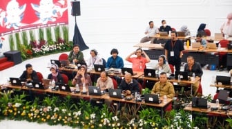 Petugas memantau hasil rekapitulasi sementara pemungutan suara Pemilihan Umum (Pemilu) 2024 di Gedung Komisi Pemilihan Umum (KPU) Republik Indonesia di Jakarta, Kamis (15/2/2024). [Suara.com/Alfian Winanto]