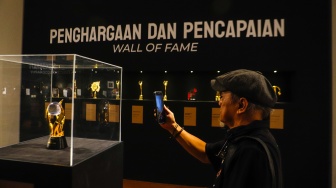 Pengunjung saat melihat Pameran Retrospektif 50 Tahun God Bless di Galeri Nasional, Jakarta, Jumat (16/2/2024). [Suara.com/Alfian Winanto]