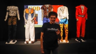 Personil God Bless, Ahmad Albar berpose di depan galeri kostum panggungnya saat Pameran Retrospektif 50 Tahun God Bless di Galeri Nasional, Jakarta, Jumat (16/2/2024). [Suara.com/Alfian Winanto]