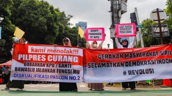 Tolak Hasil Quick Count, Emak-emak Ini Kibarkan Bendera Kuning di Depan KPU