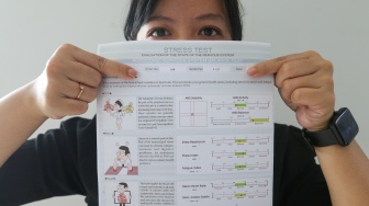 Seorang warga menunjukkan hasil tes heart rate variability (HRV) untuk mengetahui kondisi kesehatan mental di RSUD Tamansari, Jakarta, Selasa (20/2/2024). [Suara.com/Alfian Winanto]