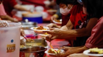 Warga keturunan Tionghoa mengambil makanan khas Lontong Cap Go Meh saat perayaan di Vihara Amurva Bhumi, Jakarta, Jumat (23/2/2024). [Suara.com/Alfian Winanto]