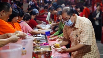 Warga keturunan Tionghoa mengambil makanan khas Lontong Cap Go Meh saat perayaan di Vihara Amurva Bhumi, Jakarta, Jumat (23/2/2024). [Suara.com/Alfian Winanto]