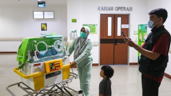 Petugas kesehatan membawa bayi yang baru lahir dengan inkubator di RSUD Kramat Jati, Jakarta, Kamis (29/2/2024). [Suara.com/Alfian Winanto]