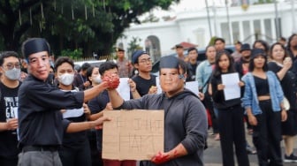 Sejumlah aktivis menampilkan aksi teaterikal dengan memakai topeng Presiden Joko Widodo dan Menhan Prabowo Subianto saat Aksi Kamisan ke-807 di seberang Istana Merdeka, Jakarta, Kamis (29/2/2024). [Suara.com/Alfian Winanto]
