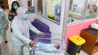 Tenaga kesehatan membawa bayi yang baru lahir di RSUD Kramat Jati, Jakarta, Kamis (29/2/2024). [Suara.com/Alfian Winanto]
