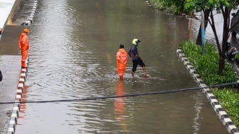 Warga berjalan melewati banjir di sekitar Cempaka Putih, Jakarta, Kamis (29/2/2024). [Suara.com/Alfian Winanto]