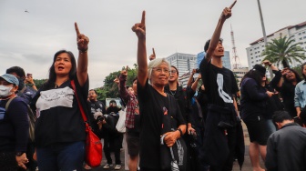 Penggerak Aksi Kamisan, Maria Catarina Sumarsih (tengah) bersama sejumlah aktivis, akademisi, mahasiswa, dan elemen masyarakat sipil menunjuk ke arah istana Ssaat mengikuti Aksi Kamisan ke-807 di seberang Istana Merdeka, Jakarta, Kamis (22/2/2024). [Suara.com/Alfian Winanto]
