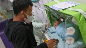 Orang tua dari bayi yang baru lahir melantunkan adzan di RSUD Kramat Jati, Jakarta, Kamis (29/2/2024). [Suara.com/Alfian Winanto]