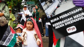 Massa mengangkat poster berisi tuntutan saat menggelar Aksi Bela Palestina di depan Kedutaan Besar Mesir, Jakarta, Senin (4/3/2024). [Suara.com/Alfian Winanto]
