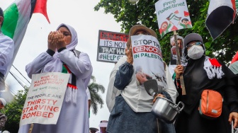 Massa mengangkat poster berisi tuntutan saat menggelar Aksi Bela Palestina di depan Kedutaan Besar Mesir, Jakarta, Senin (4/3/2024). [Suara.com/Alfian Winanto]
