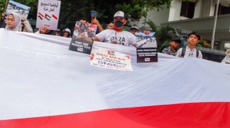 Massa mengangkat poster berisi tuntutan saat menggelar Aksi Bela Palestina di depan Kedutaan Besar Mesir, Jakarta, Senin (4/3/2024). [Suara.com/Alfian Winanto]
