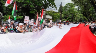 Massa mengangkat poster berisi tuntutan saat menggelar Aksi Bela Palestina di depan Kedutaan Besar Mesir, Jakarta, Senin (4/3/2024). [Suara.com/Alfian Winanto]
