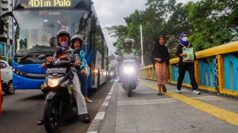 Pengendara sepeda motor melintas di trotoar kawasan Matraman, Jakarta, Selasa (5/3/2024). [Suara.com/Alfian Winanto]