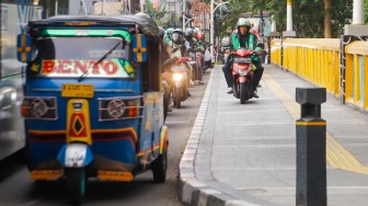 Pengendara sepeda motor melintas di trotoar kawasan Matraman, Jakarta, Selasa (5/3/2024). [Suara.com/Alfian Winanto]