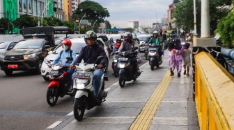 Pengendara sepeda motor melintas di trotoar kawasan Matraman, Jakarta, Selasa (5/3/2024). [Suara.com/Alfian Winanto]