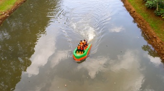 Petugas UPS Badan Air Dinas Lingkungan Hidup DKI Jakarta menaiki perahu motor berbahan botol plastik bekas di Kanal Banjir Timur, Duren Sawit, Jakarta, Rabu (6/3/2024). [Suara.com/Alfian Winanto]