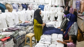 Pengunjung memilih pakaian di Pasar Tanah Abang, Jakarta, Kamis (7/3/2024). [Suara.com/Alfian Winanto]
