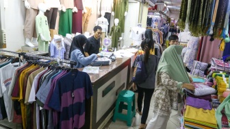 Pengunjung memilih pakaian di Pasar Tanah Abang, Jakarta, Kamis (7/3/2024). [Suara.com/Alfian Winanto]
