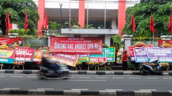 Pengendara melintas didepan karangan bunga menolak kecurangan pemilu di depan Kantor DPP PDI Perjuangan di Jakarta, Jumat (8/3/2024). [Suara.com/Alfian Winanto]