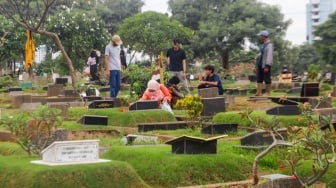 Warga melakukan ziarah kubur di TPU Karet Bivak, Jakarta, Minggu (10/3/2024). [Suara.com/Alfian Winanto]