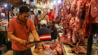 Pedagang memotong daging sapi di Pasar Senen, Jakarta, Senin (11/3/2024). [Suara.com/Alfian Winanto]
