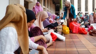 Petugas membagikan menu berbuka puasa di Masjid Istiqlal, Jakarta, Selasa (12/3/2024). [Suara.com/Alfian Winanto]