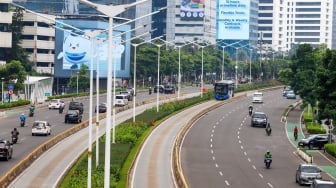 Kendaraan melintas di Jalan Sudirman, Jakarta, Selasa (12/3/2024). [Suara.com/Alfian Winanto]