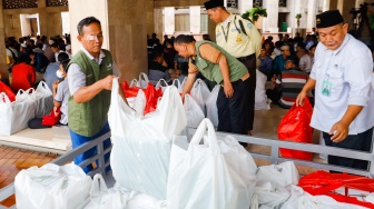 Petugas membagikan menu berbuka puasa di Masjid Istiqlal, Jakarta, Selasa (12/3/2024). [Suara.com/Alfian Winanto]