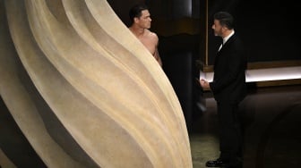 Pembawa acara Jimmy Kimmel (kanan) dan aktor John Cena (kiri) berbicara di atas panggung pada Academy Awards Tahunan ke-96 di Dolby Theatre di Hollywood, California, Minggu (10/3/2024).  [Patrick T. Fallon / AFP]