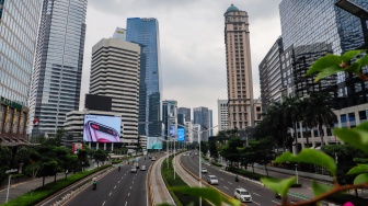 Kendaraan melintas di Jalan Sudirman, Jakarta, Selasa (12/3/2024). [Suara.com/Alfian Winanto]