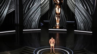 Aktor John Cena saat membacakan penghargaan untuk Desain Kostum Terbaik di atas panggung pada Academy Awards Tahunan ke-96 di Teater Dolby di Hollywood, California, Minggu (10/3/2024).  [Patrick T. Fallon / AFP]