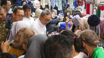 Menteri Perdagangan (Mendag) Zulkifli Hasan  berbincang dengan pedagang saat melakukan kunjungan di Blok A Pasar Tanah Abang, Jakarta, Kamis (14/3/2024). [Suara.com/Alfian Winanto]