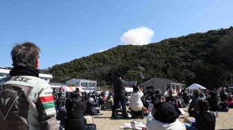 Pengunjung menyaksikan asap mengepul dari balik bukit setelah Roket Kairos milik Space One di meledak saat lepas landas, dari situs Spaceport Kii di Kushimoto, prefektur Wakayama, Jepang, Rabu (13/3/2024).  [ JIJI PRESS / AFP]