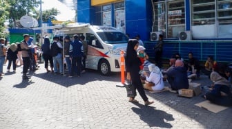 Warga antre untuk menukarkan uang baru di Pasar Tebet Barat, Jakarta, Selasa (19/3/2024). [Suara.com/Alfian Winanto]